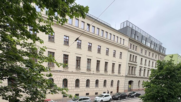A multi-story building with a classic architectural style, a street with parked cars, and a balcony with a metal railing. - Beautiful 1-bedroom apartment in fantastic Poznań location (Poznań)