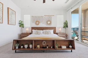 A modern bedroom with a wooden bed, bedside tables, macramé wall hangings, and a balcony view. - Lakefront Indio Luxury Tulum Vacation Home~Pool~Views. (Indio)