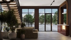 Un vestíbulo moderno con una escalera, zona de estar y un mostrador de recepción.