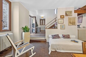 A bedroom with a bed, a chair, a staircase, and a view of the outdoors. - The Place to Be, Outdoor Dining (Laveno Mombello)