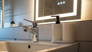 A bathroom sink with a modern faucet and a soap dispenser. - Shaft by Loftigo | Apartment with a wellness shower (Übach-Palenberg)