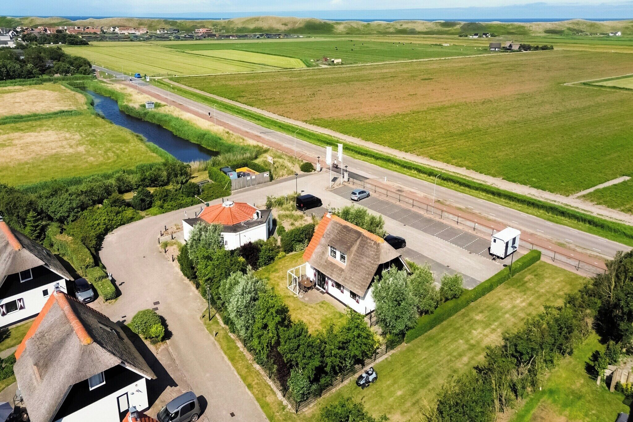 An aerial view of a rural area with houses, a road, and fields.