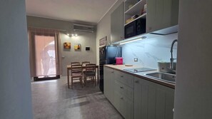 A compact kitchen with a dining area, a microwave, a sink, and cabinets. - Cozy Apartment with Pool & Private Garden near Cagliari (La Maddalena)