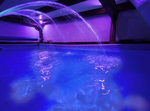 A swimming pool with water jets and a hexagonal pattern at the edge. - Cozy Apartment with Pool & Private Garden near Cagliari (La Maddalena)
