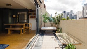 A balcony with a wooden table, chairs, a sofa, and a glass table. - Refined 3BDR Retreat with Skyline Views (Greater London)