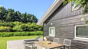 A deck with a table and chairs, a grill, and a house number 12. - "Ruka" - 600m from the sea by Interhome (Løkken)
