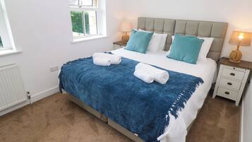 Una camera da letto con un letto, due comodini, una finestra e un termosifone.