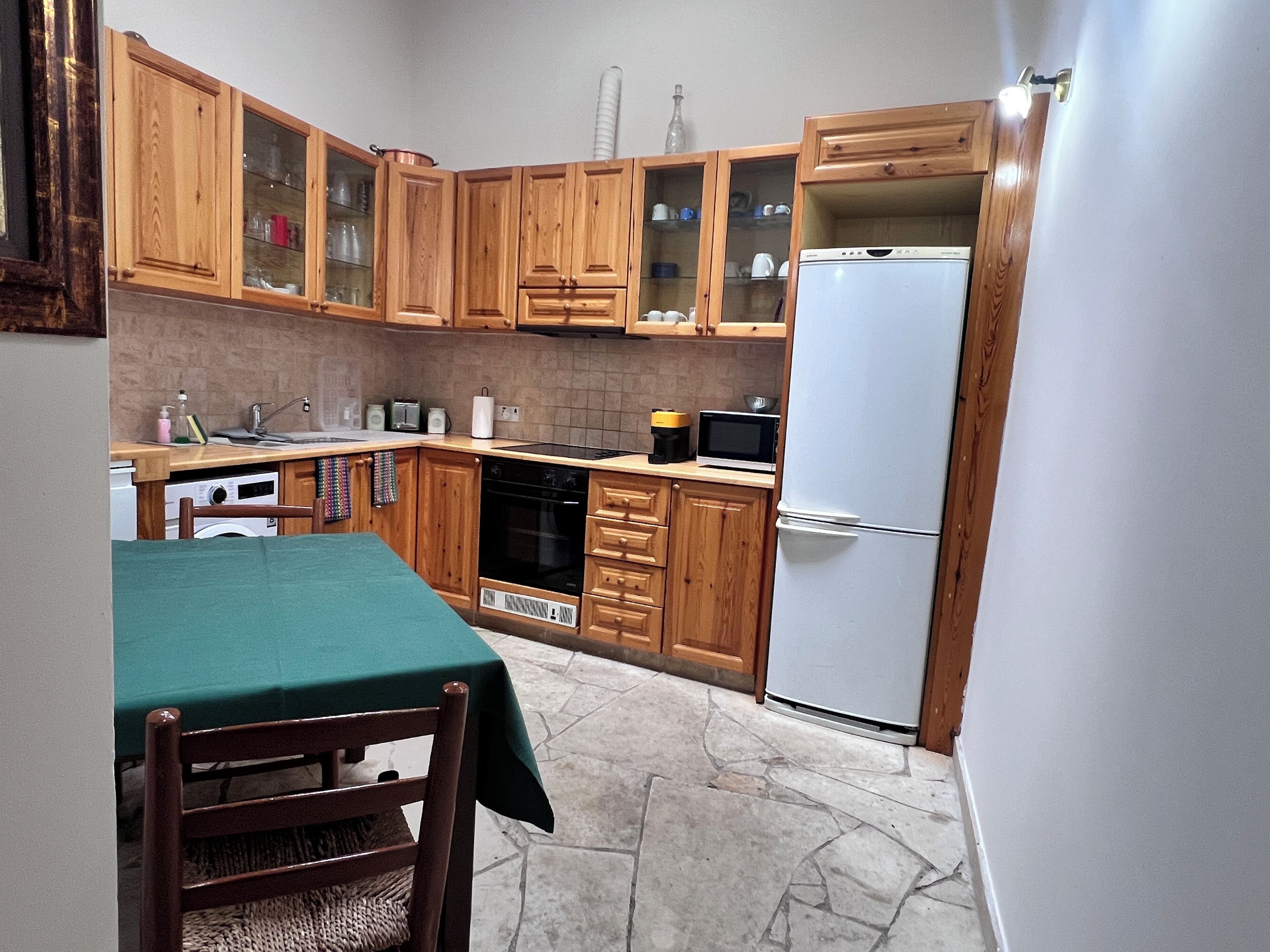 A compact kitchen with wooden cabinets, a microwave, a dishwasher, and a refrigerator.