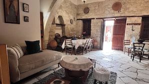 Un interno rustico con parete in pietra, arredi in legno e zona pranzo.