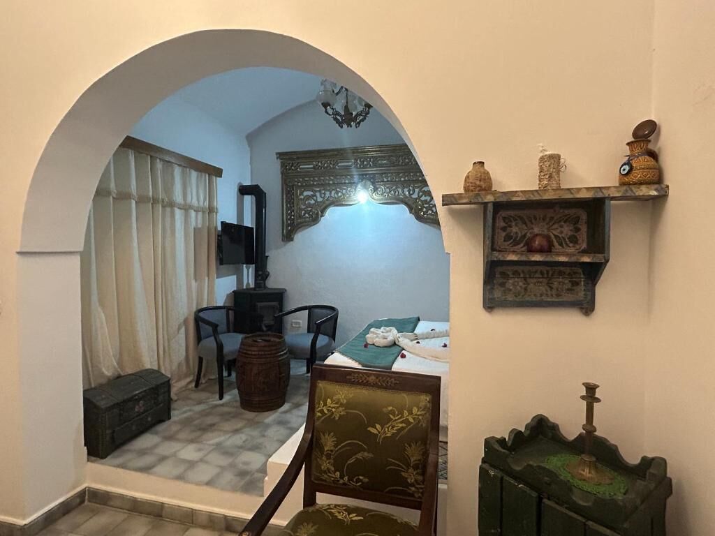 Une pièce comprenant un coin repas, une petite table, une chaise, une étagère décorative et une étagère fixée au mur.