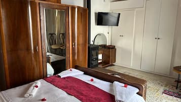 Ein Hotelzimmer mit Bett, Holzschrank, Fernseher und Schreibtisch.