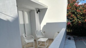 A balcony with two white chairs, a white table, and a white railing. - Guesthouse DarHamdoun (Hammam Al Agzaz)