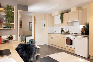 Eine moderne Küche mit Holzschränken, einem eingebauten Backofen und einem weißen Kühlschrank.
