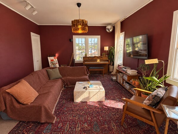 Een woonkamer met een bank, salontafel en een piano.