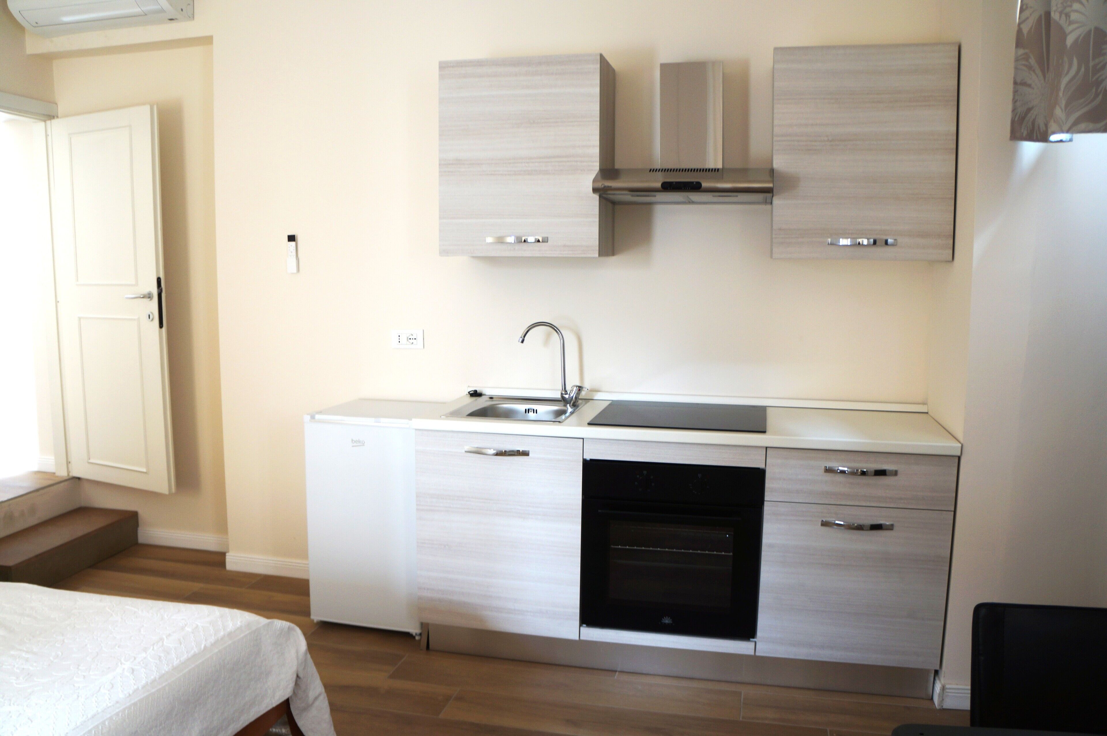 A compact kitchen with a dishwasher, oven, and a built-in microwave.