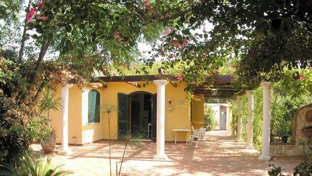 A yellow building with a covered patio area, columns, and potted plants. - Detached house, 2.000m² with garden, orchard. Four-room apt 123m², ground floor. (Arenella)