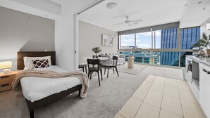 Ein modernes Hotelzimmer mit Bett, Essbereich und einer Küchenzeile.