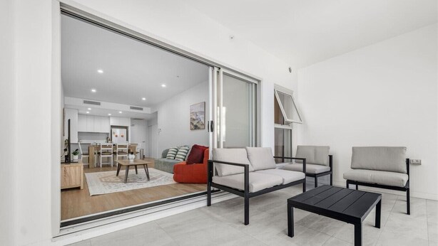 A modern living room with a sofa, armchairs, and a coffee table.