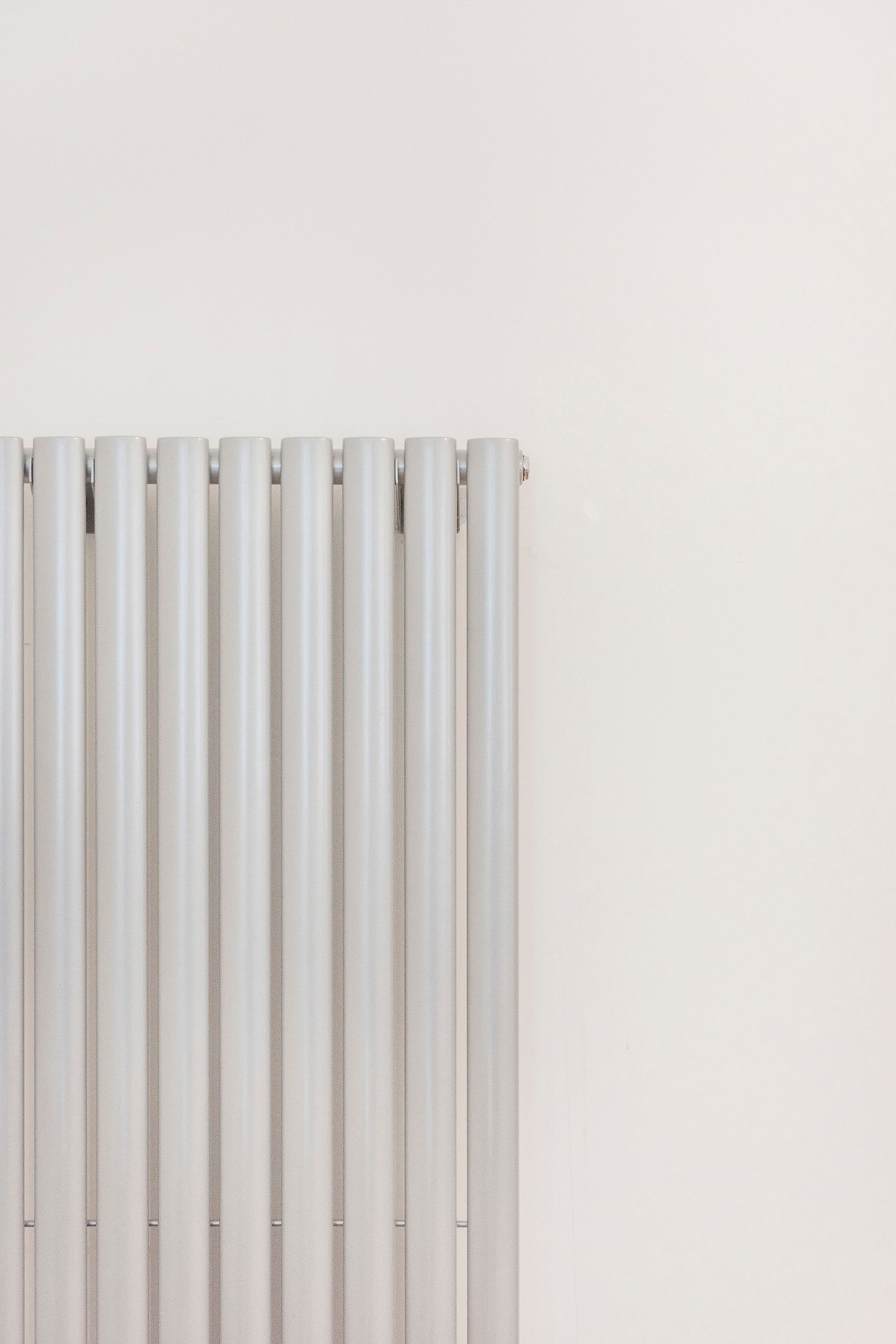 Een witte radiator voor een effen muur.