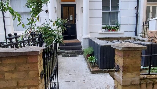 A two-story house with a front door, a small front yard, and a brick wall. - Fine Studio Flat - Shepherds Bush Notting Hill (London)