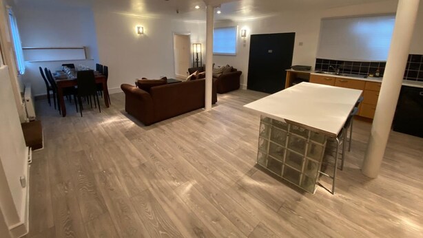 A spacious living area with a dining table, sofa, and kitchen area. - Large 3 Bedroom Flat Earl s Court West Kensington (London)