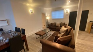 A modern living room with a dining area, a sofa set, and a coffee table. - Large 3 Bedroom Flat Earl s Court West Kensington (London)