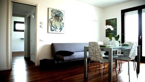 Un espacio moderno para vivir con sofá, mesa de comedor, sillas y obras de arte en las paredes.