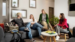 A modern interior with a sofa, chairs, a round table, and framed pictures on the walls. - Student Only Phoenix Court (Bristol)