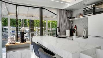 A modern kitchen with a marble countertop, a built-in oven, and a view of the outdoors.