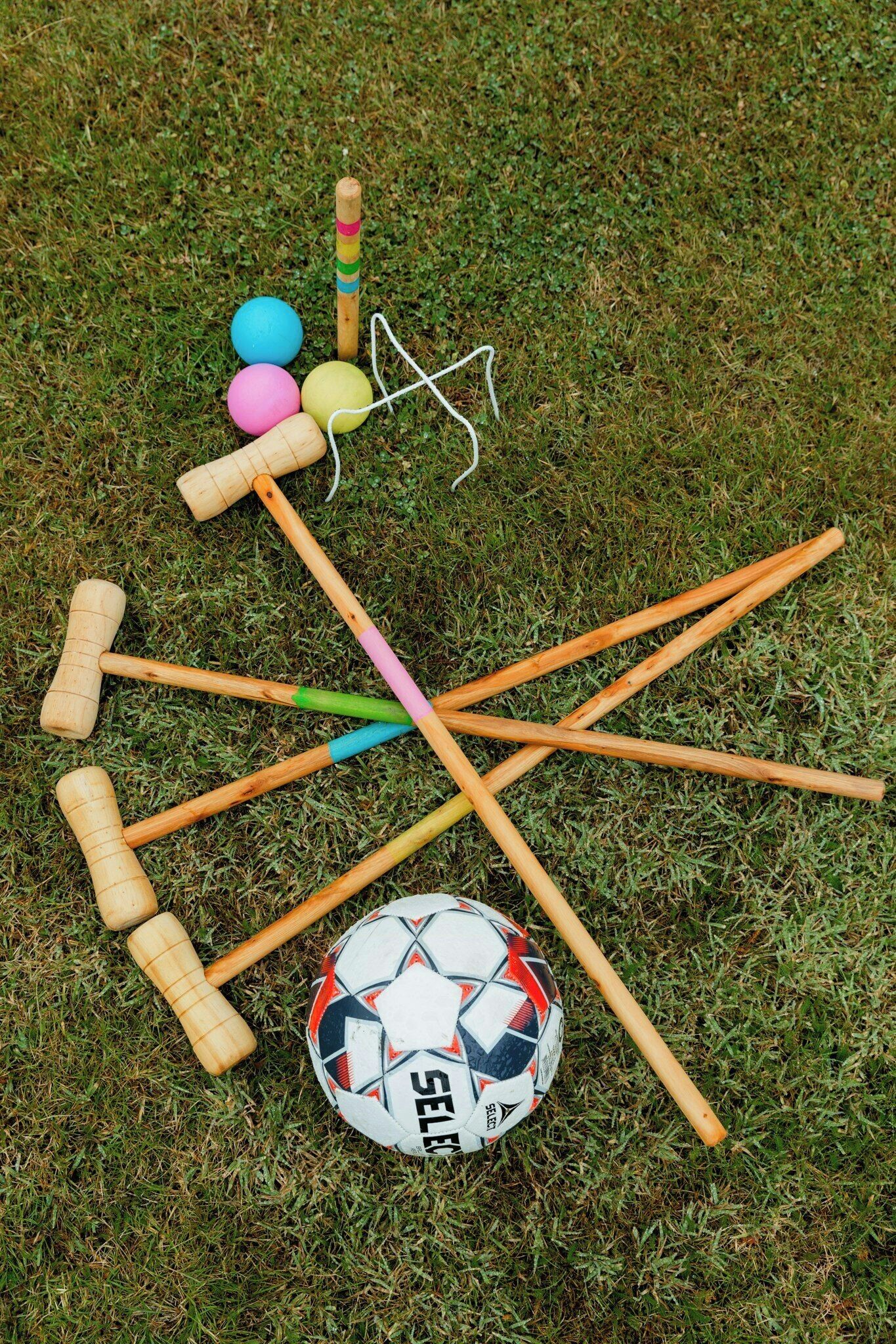 Un jeu de croquet avec un ballon de football sur l’herbe.