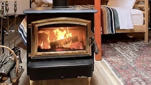 Ein Zelt mit Holzofen, einem Bett und einem Kamin.
