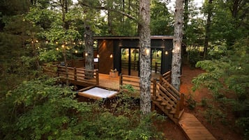 Een chalet met terras, omringd door bomen.