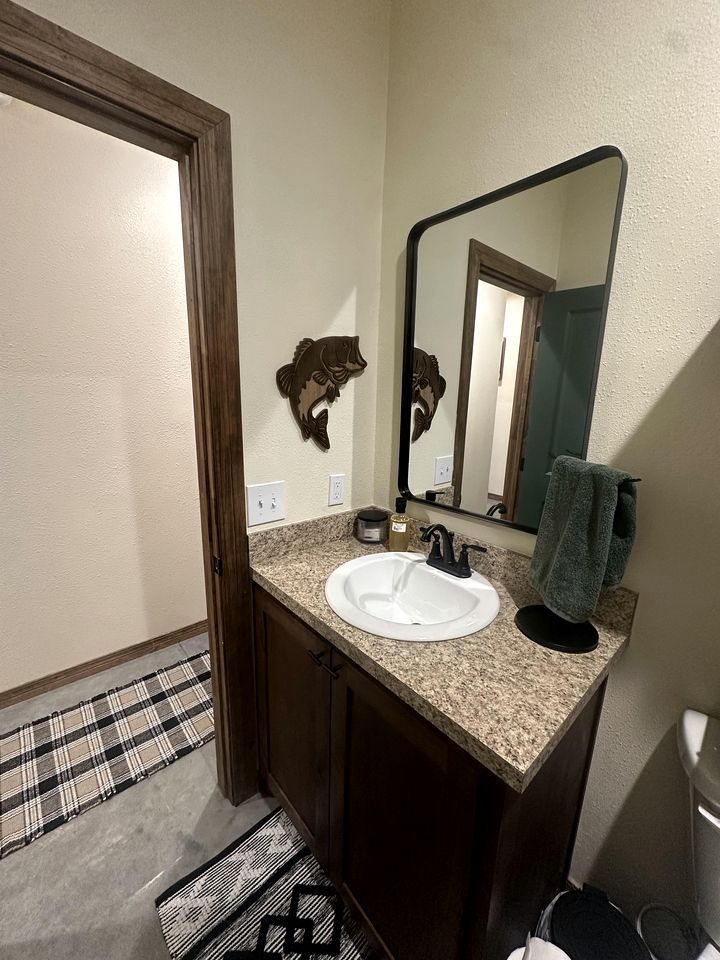 A bathroom with a white sink, a mirror, a towel, and a door.