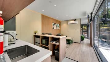 A modern kitchen with built-in appliances, a dining area with a view, and a compact living space.