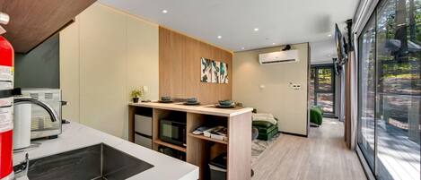 Una cocina moderna con electrodomésticos integrados, un comedor con vistas y un espacio de sala compacto.