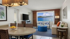 A modern living room with a dining area, a large TV, and a view of the sea. - St. Thomas 2BR Oceanside Villa at Marriott’s Frenchman’s Cove – Beach & Resort A (Southside)