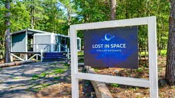 A sign with 'LOST IN SPACE' and 'STELLAR GATEWAYS' text, a small cabin-like structure, and a wooden walkway.