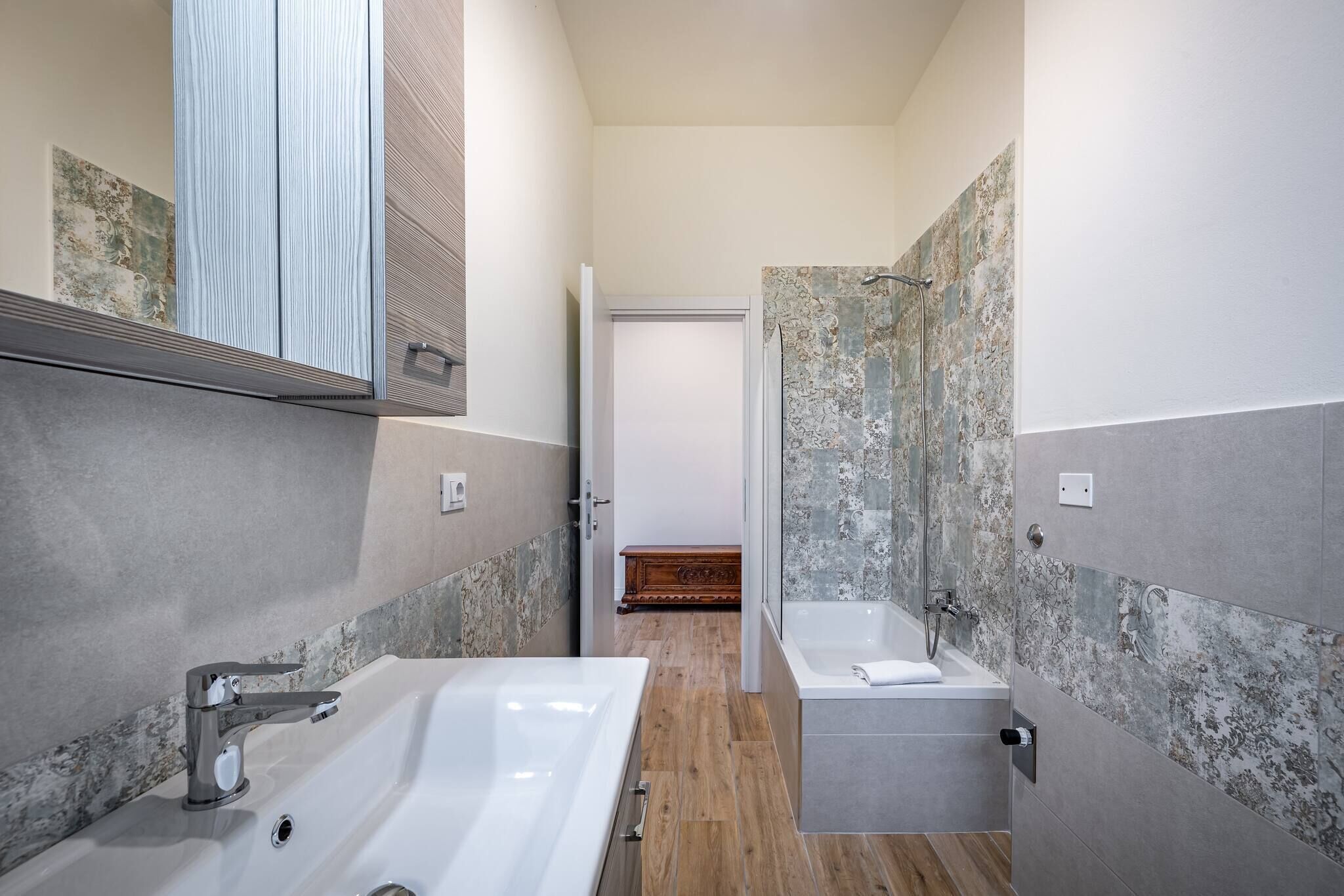 A modern bathroom with a large bathtub, a smaller sink, and a shower area.