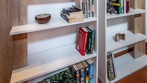 A modern bookshelf with multiple shelves, some containing books and decorative items. - Vellutini (Florence)