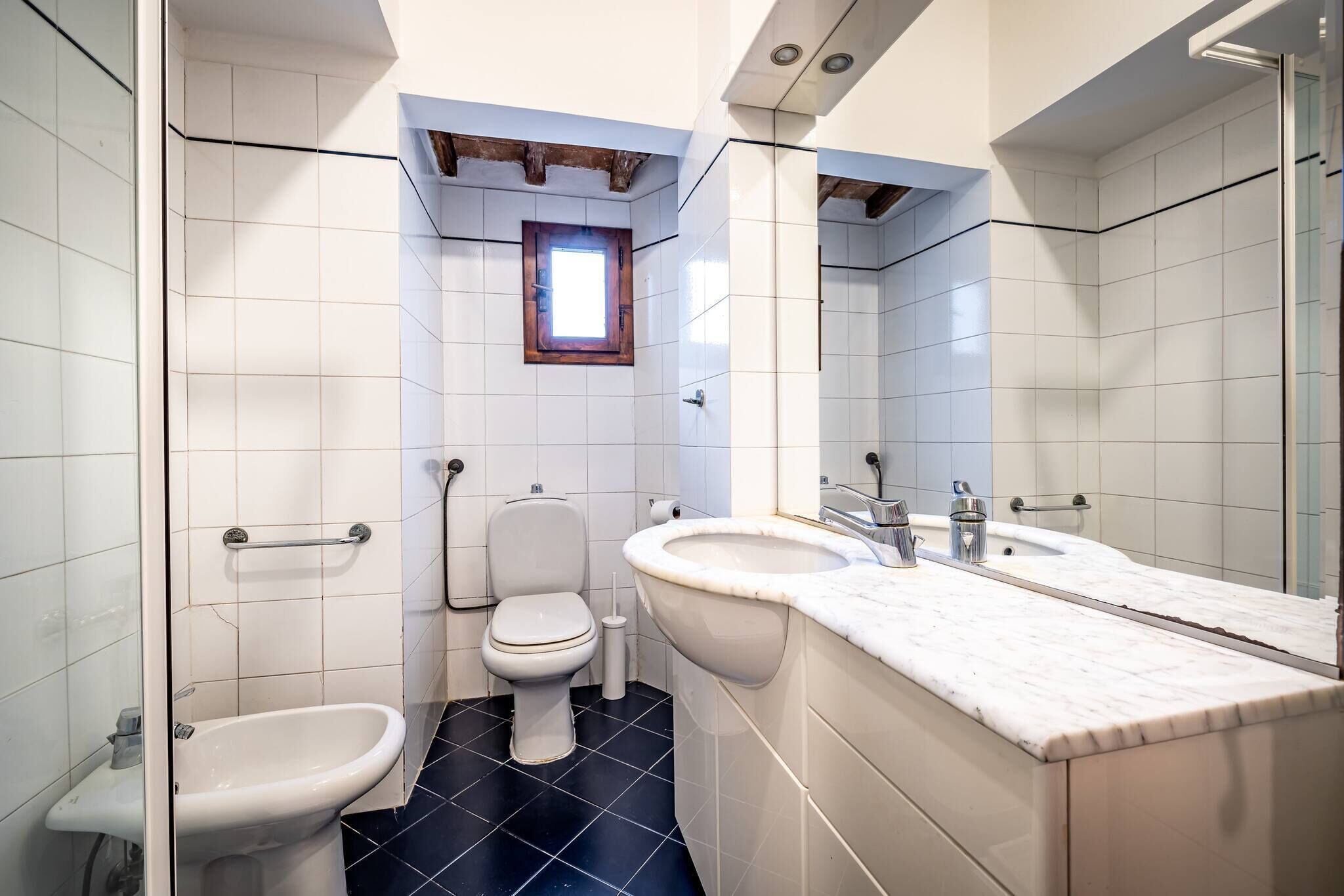 A bathroom with a toilet, bidet, and sink.