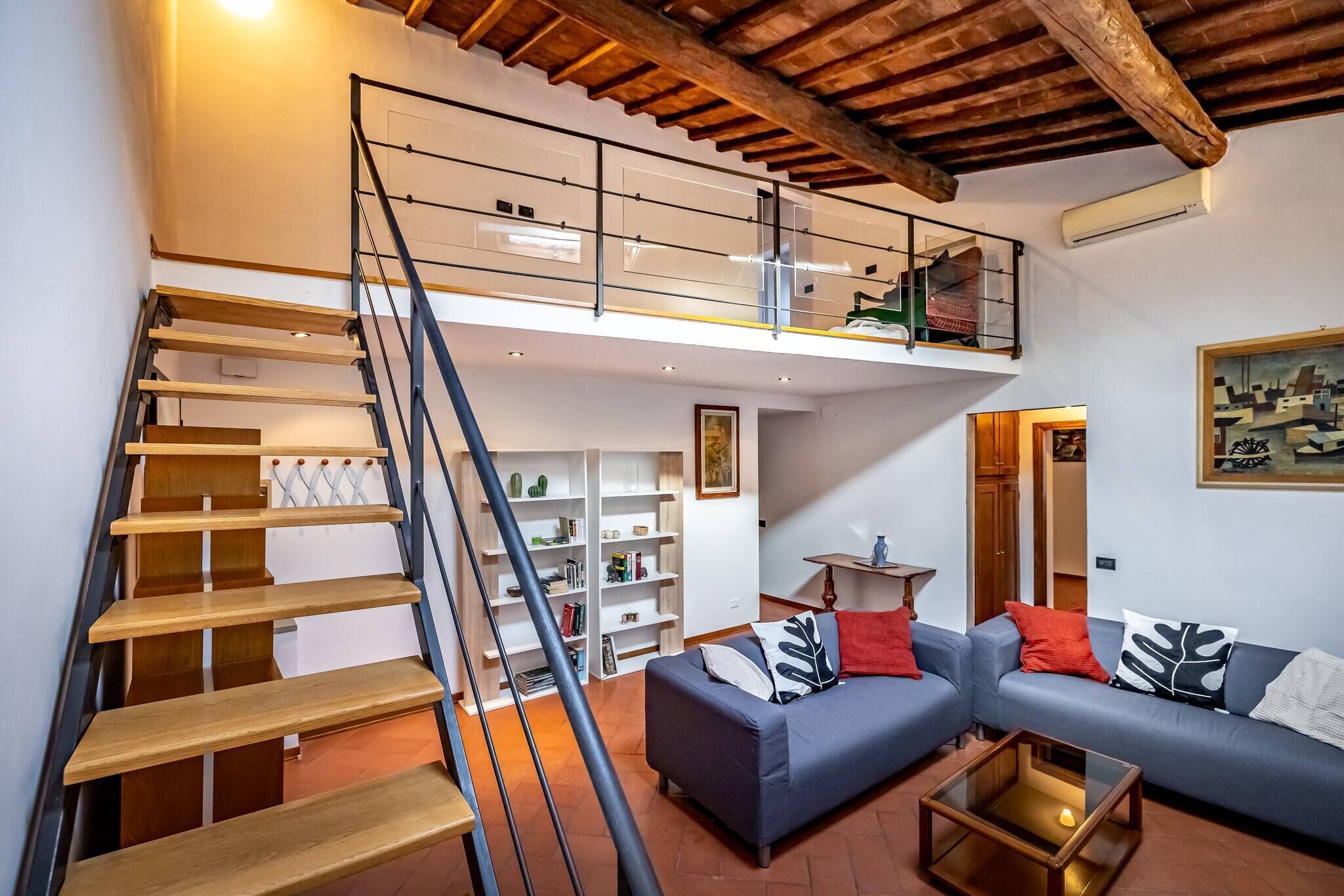 A modern living room with a staircase leading to a loft.