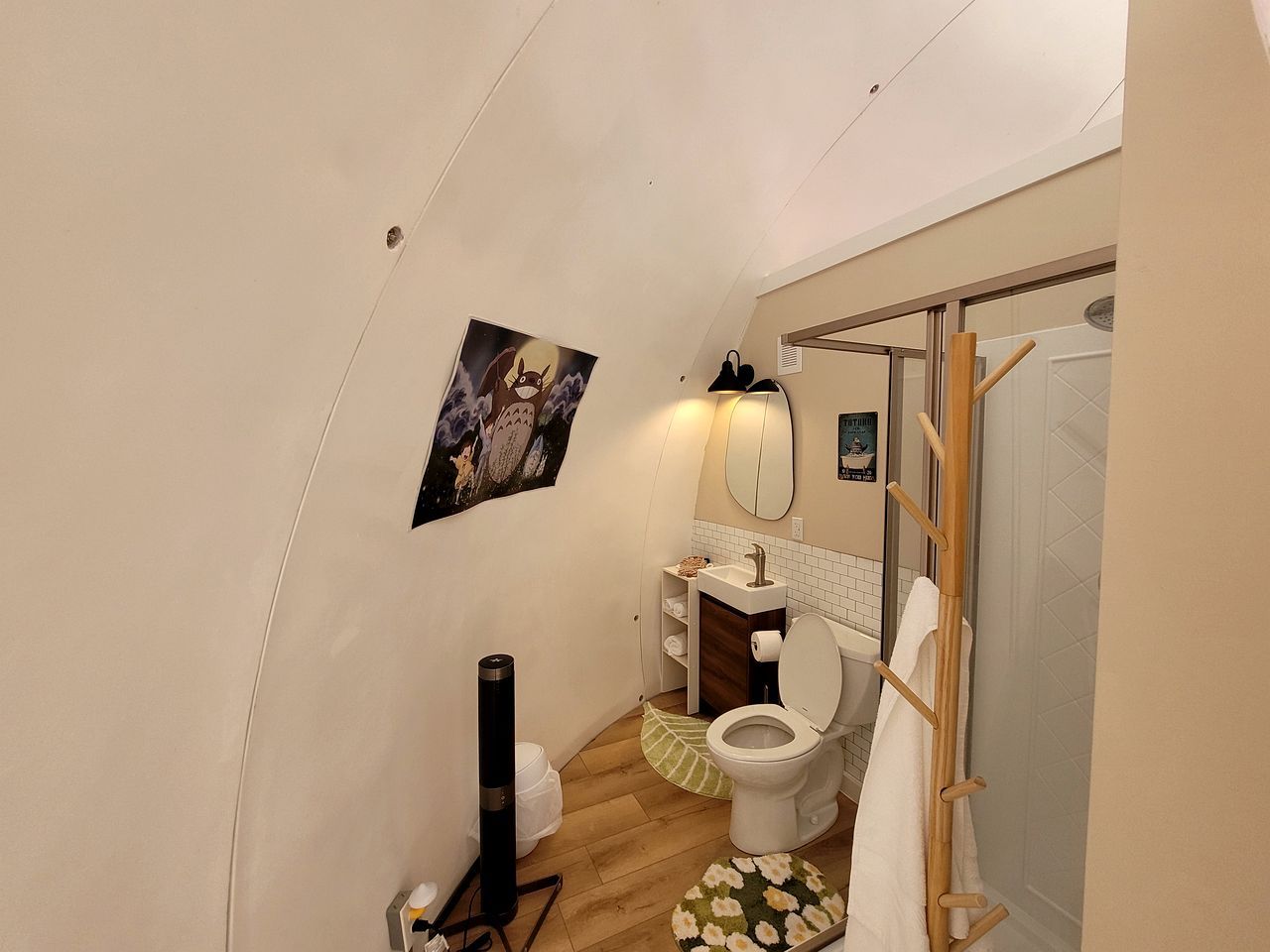 A compact bathroom with a toilet, sink, and shower.