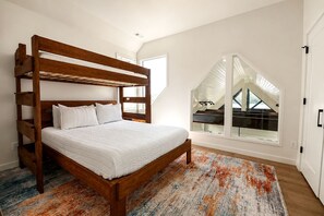 A bunk bed with a wooden frame and white bedding in a room with a large window and a view of a balcony. - Modern Waterfront Home With Lake Views in Water’s Edge Tennessee (Tracy City)