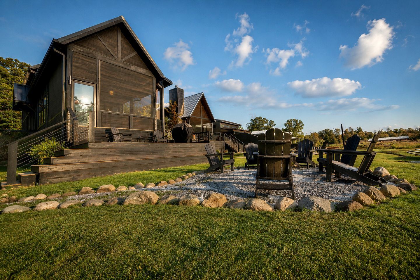 Une cabane en bois moderne dotée d’une terrasse, d’un espace salon extérieur et d’un foyer.