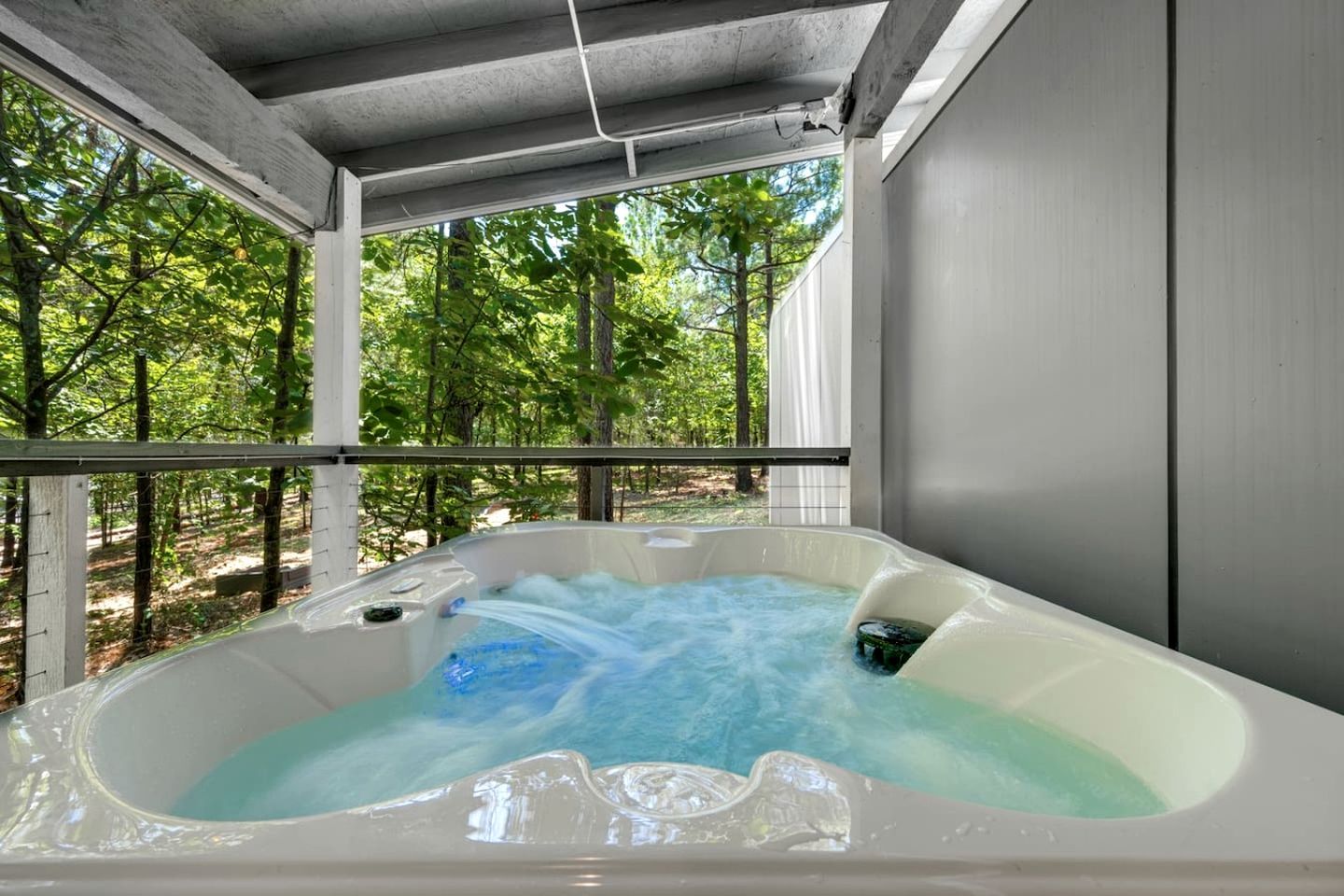 A hot tub with a view of a forested area.