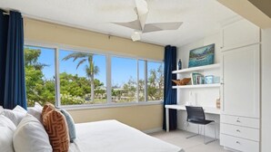 Una camera da letto con un letto, una scrivania, una sedia e vista sul verde.