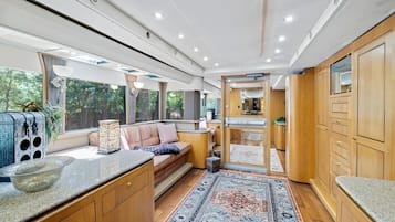A modern interior with a seating area, wooden cabinets, and a large window.