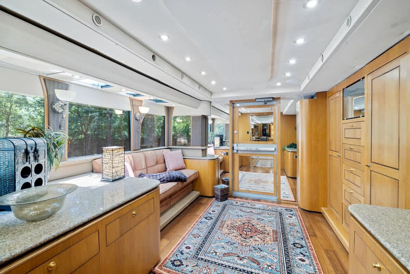 Un intérieur moderne et compact, comprenant un coin cuisine, un espace salon et de grandes fenêtres.