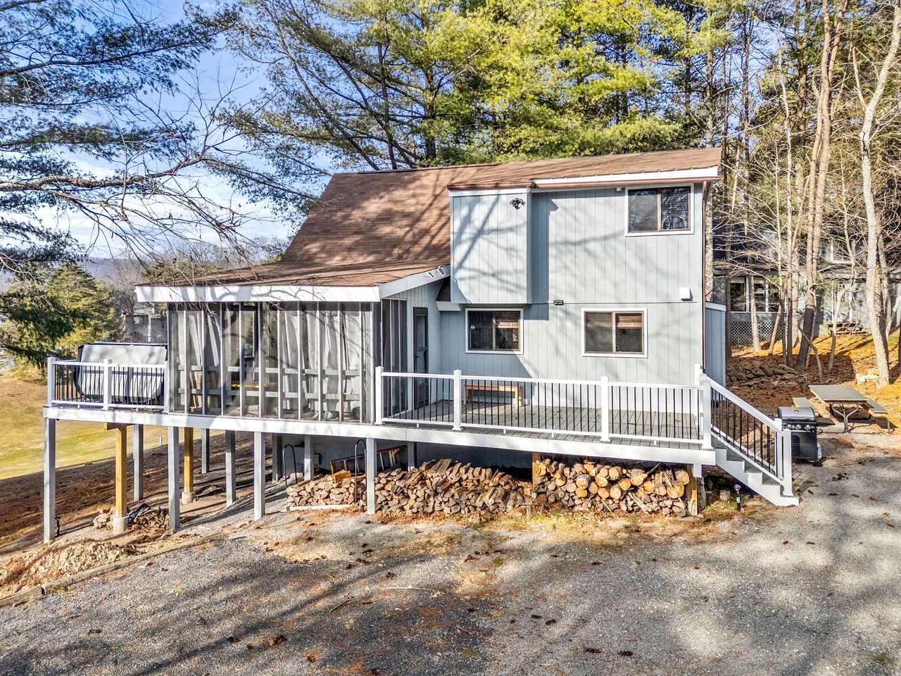 A two-story house with a covered porch and a deck.
