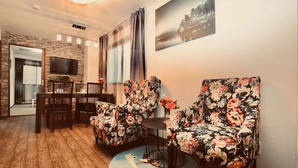 A living room with a dining area, a fireplace, and a painting on the wall. - Spacious 4-bedroom apartment in heart of Osaka with AC (Osaka)